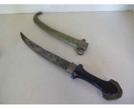 An Eastern curved dagger with ornate brass scabbard and hardwood handle, blade length 23cm, general wear, some dents to scabb