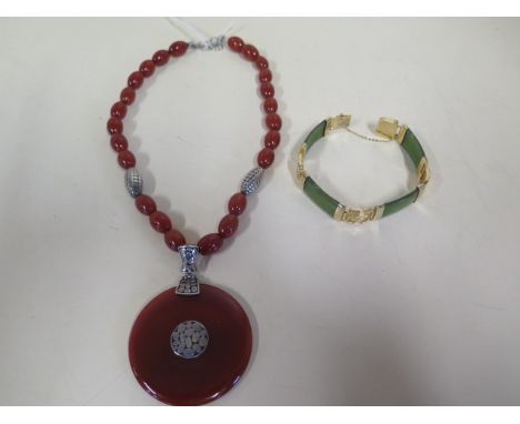 A silver and agate necklace, the circular pendant diameter 56mm, necklace length 48cm, and a gold plated jade/jadeite bracele