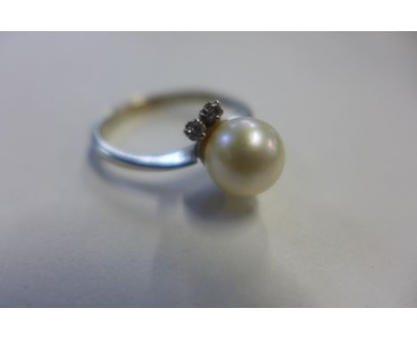 An 18ct white gold pearl and diamond ring set with a single pearl approx 8mm in diameter with four small diamonds set in pair