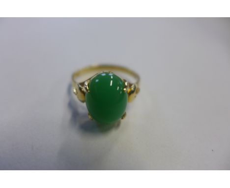 A yellow jade ring, stamped 18k but tested to 9ct or above, the cabachon polished jade stone measures approx 12x8mm - weight 