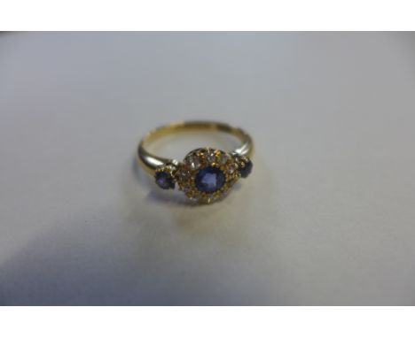 A sapphire and diamond, fully hallmarked 18ct gold ring, set with a pale blue sapphire approx 3mm diameter, surrounded by ten