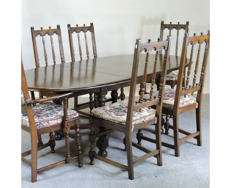 An Ercol dark elm draw leaf table, 215 x 108 overall, together with six matching chairs 