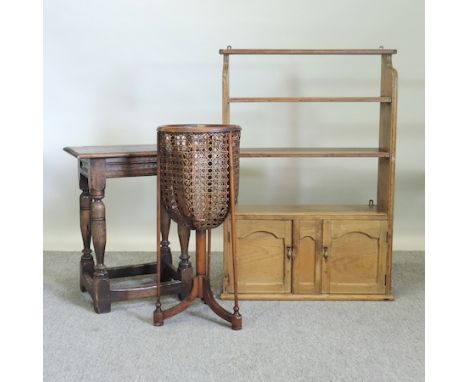 An antique pine hanging wall shelf, 63cm, together with a cane jardiniere stand and an oak joint stool