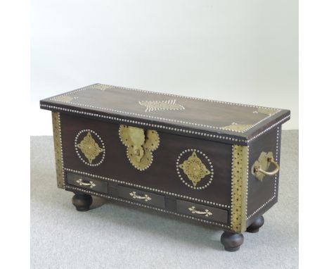 An Indian hardwood and brass mounted studded trunk, containing three drawers, on bun feet, 93cm