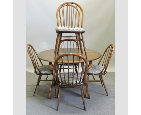 An Ercol elm drop leaf dining table, together with six spindle back chairs, to include two carvers