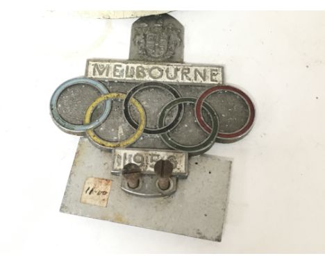 A vintage 1956 Melbourne olympics car badge, together with a vintage motorcycle helmet.