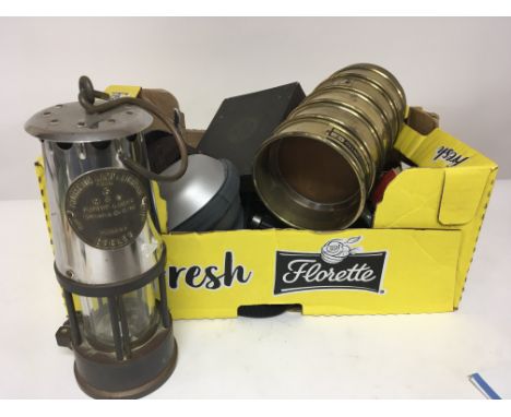 A box containing camera equipment other oddments and a miners safety lamp. Postage Category C. NO Reserve.