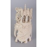 AN EARLY 20TH CENTURY INDIAN IVORY CARVING OF AN ELEPHANT BEARING A HOWDAH, its sides with carved