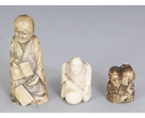 A SMALL JAPANESE MEIJI PERIOD BONE IVORY NETSUKE OF A KNEELING MAN WITH A DARUMA DOLL, 1.75in high; together with two small o