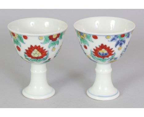 A PAIR OF CHINESE MING STYLE DOUCAI PORCELAIN STEM CUPS, each decorated with formal lotus motifs, each base with a six-charac