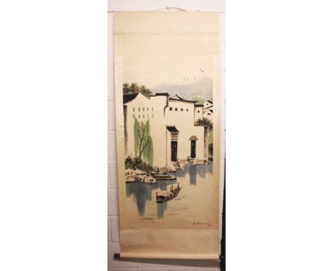 A CHINESE HANGING SCROLL PICTURE, depicting a riverside town scene, the picture itself approx. 53in x 26in.