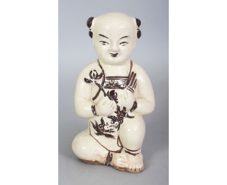 A CHINESE MING STYLE CIZHOU CERAMIC FIGURE OF A KNEELING BOY, the details in brown reserved on a cream ground, the base ungla