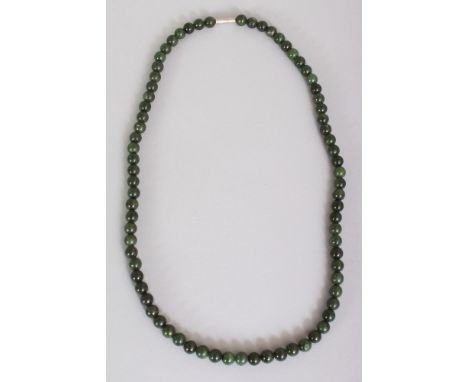 A CHINESE DARK GREEN JADE NECKLACE, composed of small spherical beads, approx. 23.25in long.