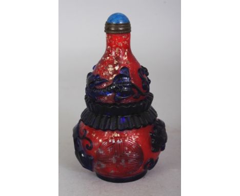 A CHINESE RED GROUND BLUE OVERLAY DOUBLE GOURD GLASS SNUFF BOTTLE & STOPPER, decorated with dragons and Shou symbols, the bas