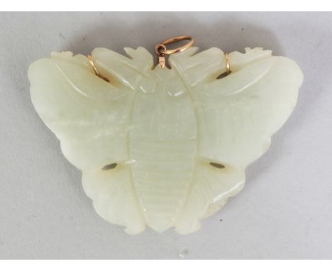 A CHINESE CELADON JADE BUTTERFLY PENDANT, with a gold clasp marked '14K' & '585', 2.25in wide & 1.5in high.