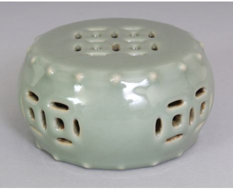 AN UNUSUAL CHINESE CELADON GLAZED MODEL OF A GARDEN SEAT, with pierced 'cash' decoration and moulded studs to the rims, the b