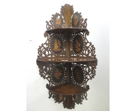 A wall hanging mahogany fretwork three tier corner display shelf with inlaid floral and figural medallion, Italian, 19th cent