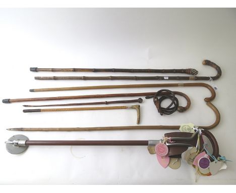 A group of wooden walking canes, riding crops and a shooting stick to include a Briggs silver banded stick and a 19th century