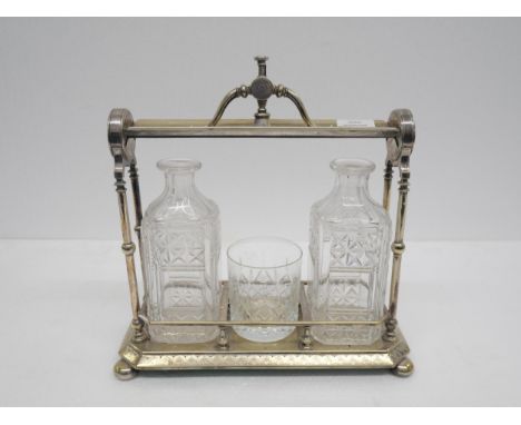 A silver plated Staniforth's patent tantalus marked Fenton Bros Sheffield with two decanters both missing stoppers and tumble