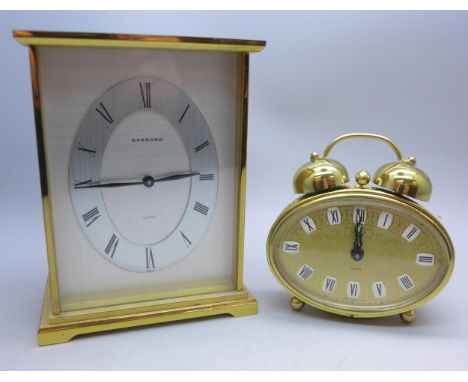 A brass Garrard carriage clock with battery movement, the case back bears inscription dated 1973, and a German made alarm clo