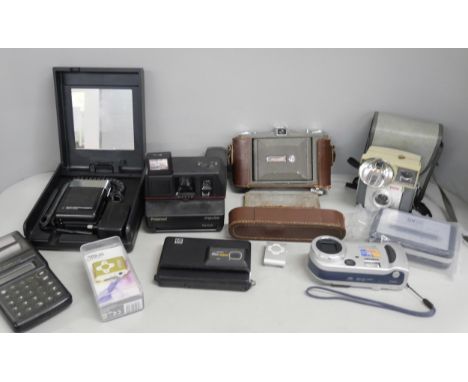 A collection of cameras including Olympus, Polaroid, Ensign with calculator, cassette player and other items