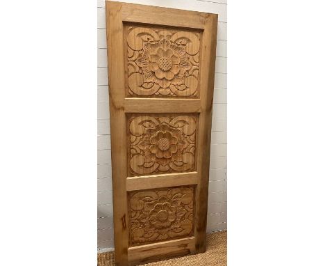 A wooden carved panel decorated with Tudor rose style flowers 