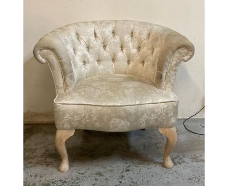 A white upholstered button back bedroom chair 