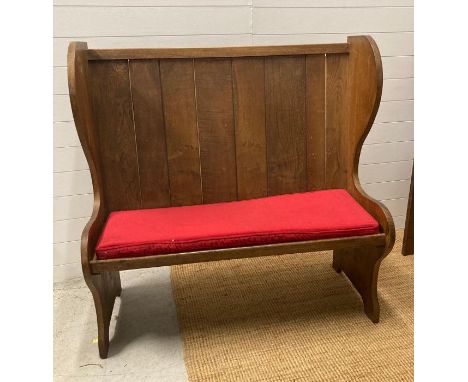 An oak vintage two seater settle with red upholstered cushions (H123cm W122cm Seat Depth 39cm)