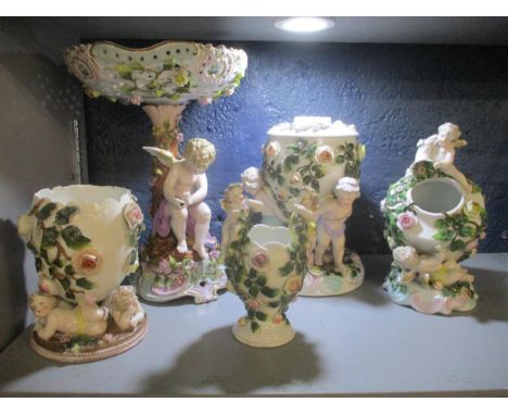 A group of 19th century Sitzendorf porcelain vases, an oil lamp base, and table comport, each decorated with winged putti and