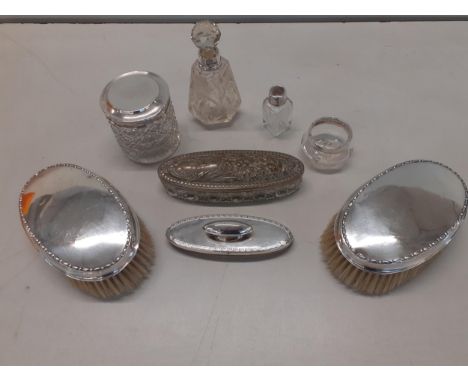 Two silver backed gents hair brushes, a silver nail buffer, silver collared scent bottles, a silver topped dressing table pot