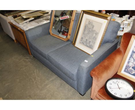 A charcoal upholstered two seater sofa bed