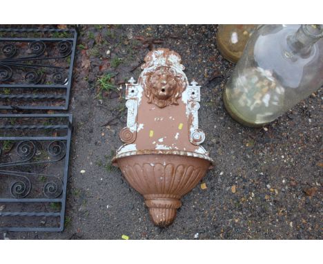 An ornate wall mounting planter with lions head decoration