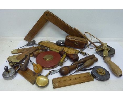 A quantity of brass hinged wooden folding rules, three Rabone steel tapes and various small tools