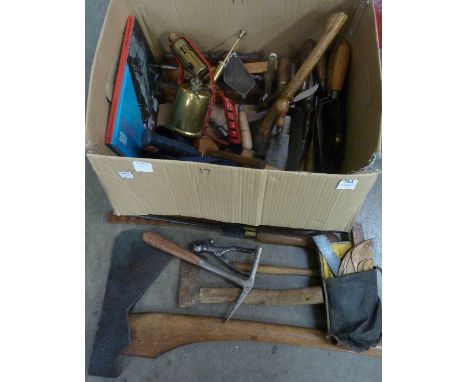 A large box of various tools including trowels, a large axe, roofers accessories, etc.