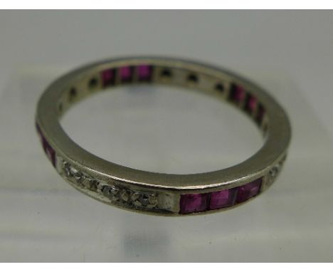 A white metal eternity ring set with diamonds and red stones, weight 3.5g, size O