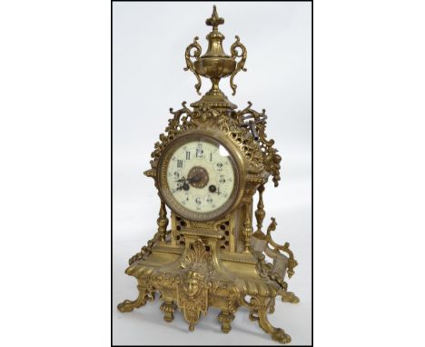 A 19th century brass ormulu 8 day French Empire  mantel clock. The clock with decorative cast brass case having finial crown 