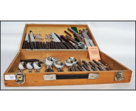 An eight person setting of retro 20th century vintage cutlery by George Butler and Co having wooden handles housed within a v