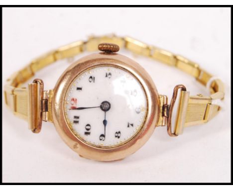 A 9ct gold / 375 marked vintage ladies wristwatch set to a later yellow metal bracelet. The watch with enamel dial and facete