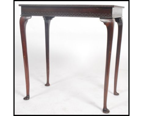 An early 20th century mahogany side / lamp table raised on cabriole legs with pad feet having a blind fret pierced frieze wit