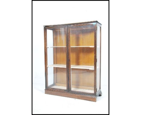 A vintage 20th century  oak china display cabinet having a pair of glazed doors with a series of shelves to the inner raised 