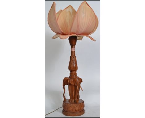 A  mid century Chinese lotus flower lamp having carved hardwood base in the form of elephants having an articulated wooden fl