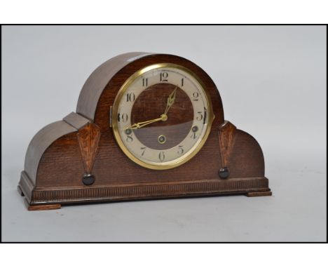 A 1930's Art Deco napoleon hat clock mechanical mantel clock having a numerical face and 3 train movement.