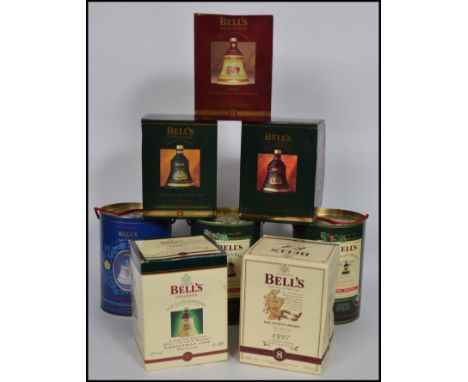 A good group of 8 boxed Bells whisky Wade bell shaped decanters in original boxes.