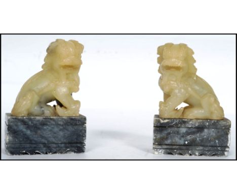 A pair of Chinese Jade temple dogs being mounted onto a soapstone socle plinth base to each. Measures 9cm high.  
