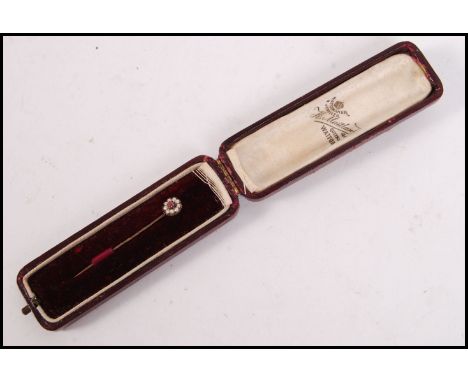 A 9ct gold seed pearl and ruby ladies stick pin / hat pin complete in the original tooled red leather presentation case. Weig
