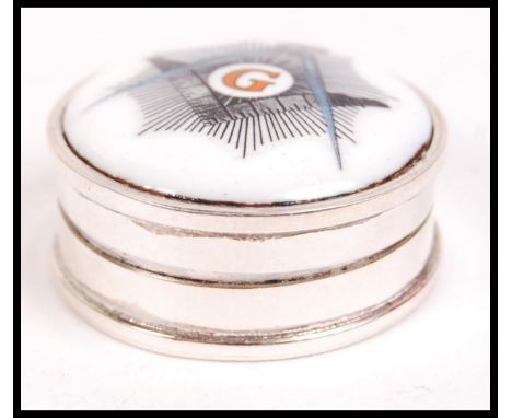 A 20th century circular silver and enamel set pill box with hinged top having an enamel roundel with masonic symbol. Total we