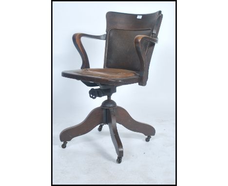A vintage 20th century 1930's oak Captains office armchair having spindle back, solid seat and swivel base