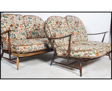 A pair of Ercol ' Windsor ' pattern 2 seat sofa settee's. Each with tapestry William Morris inspired fabric cushions having s