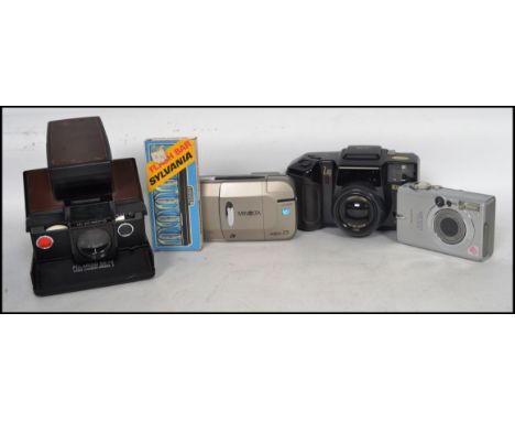 A group of vintage 20th century cameras to include an early Polaroid SX - 70 folding land camera with chrome and faux leather