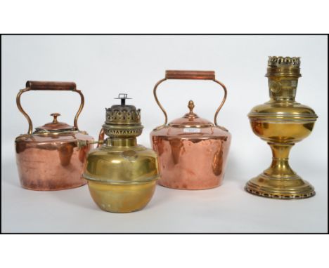 2 good Victorian copper kettles in the manner of Edward Wilkes together with a brass oil lamp and another. Measures 31cm high